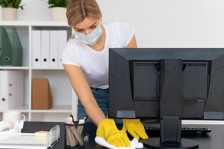 Commercial cleaning in Manhattan. Bonnie's Cleaning worker wiping off a computer desk