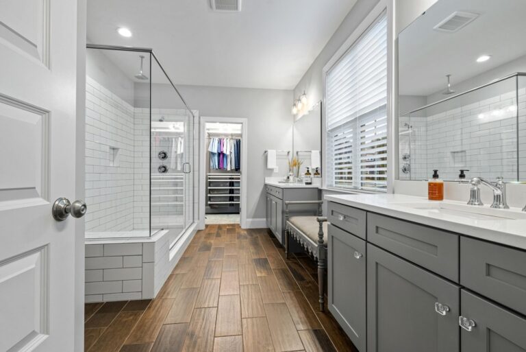 Bathroom leading to a closet with shirts hanging. Grey cabinets with white tops. Deep cleaning in Moose Jaw. Cleaning services in Kips Bay